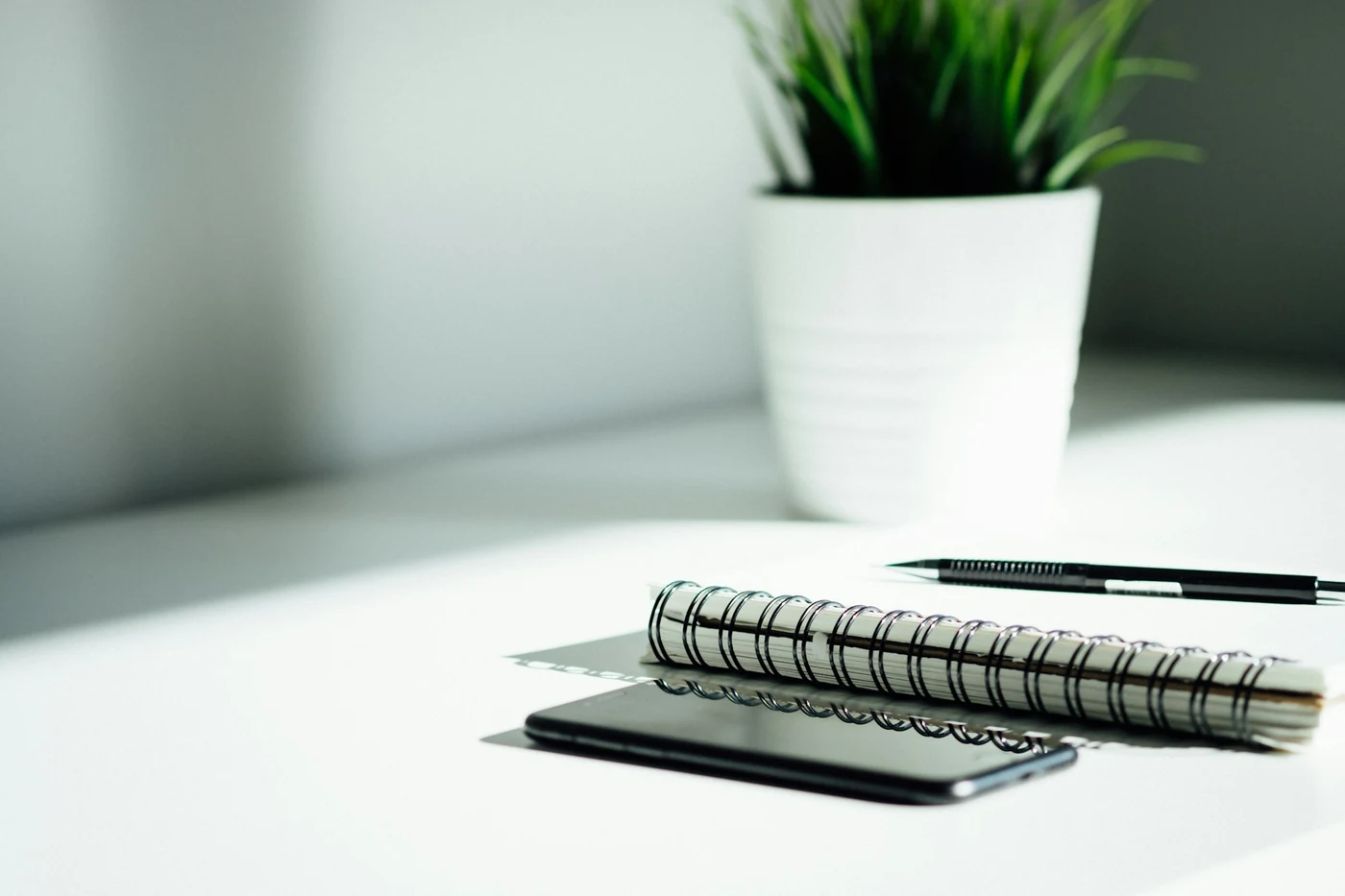 Notizbuch, Stift und Smartphone auf einem Tisch