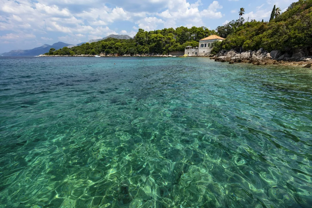 Clear turquoise water along a green coastline