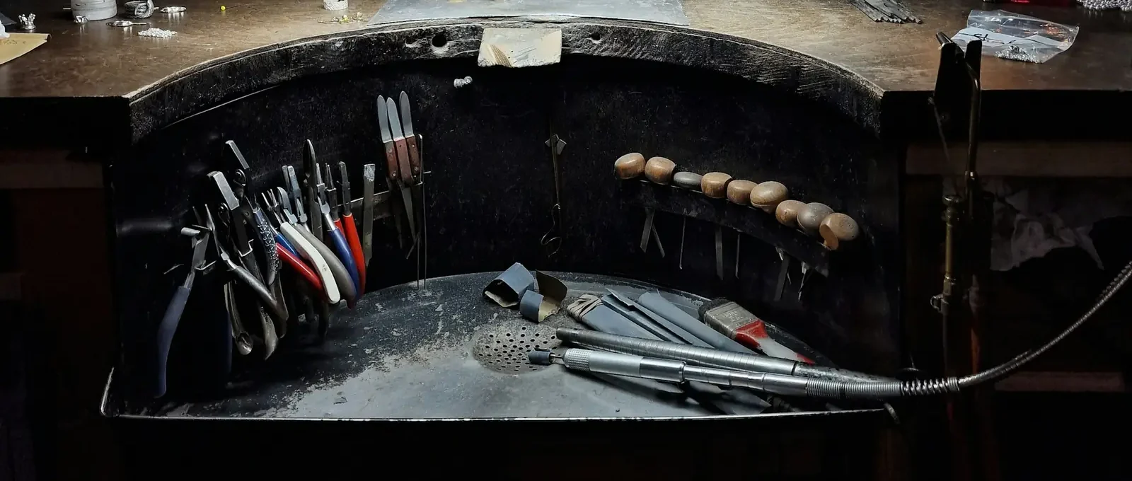 A jeweller’s bench with pliers, files and a flex-shaft hand-piece