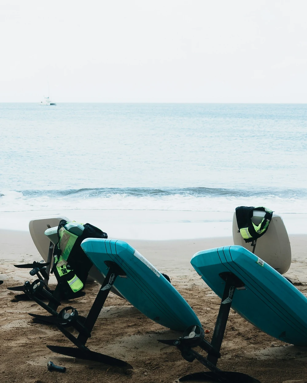 Dos tablas turquesa apoyadas en la arena junto al mar