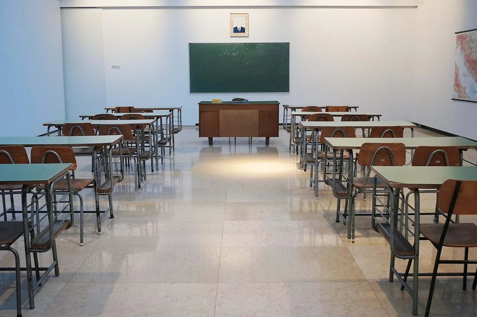 Heller Unterrichtsraum mit Tischreihen und einer Tafel
